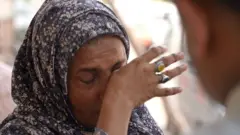 Karachi - Pakistan: umugore aririra umugabo yahohoshejwe n'ubushuhe.