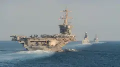 El portaaviones USS Abraham Lincoln de la Marina de EE.UU. y el destructor de misiles guiados USS Farragut y el destructor de la Marina Real británica HMS Defender navegan por el estrecho de Ormuz, en noviembre.