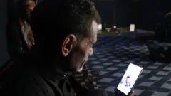 أبو وليد ينظر إلى صورة ابنه محمود، الذي لقي حتفه في المعتقل 