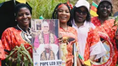 Women hold di foto of di Pope