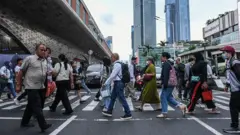 Sejumlah pekerja berjalan di fasilitas penyeberangan di kawasan Bundaran HI, Jakarta, Rabu (11/12/2024).