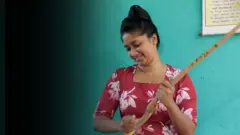 තරුණියක් කුරුඳු තලන ආකාරය මෙහි දැක්වේ.