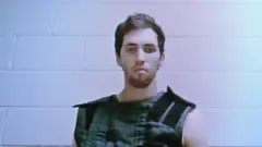 Taylor Robinson, un joven con barba, mira a la cámara un computador.