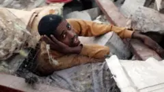 Hombre bajo escombros tras un ataque en Yemen.