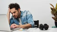 Un hombre trabajando frente al computador.