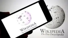 Na tej ilustracji fotograficznej widoczne jest logo Wikipedii wyświetlane na smartfonie w tle