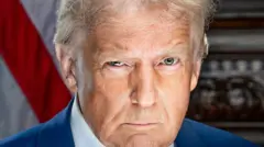 Donald Trump appears in his official presidential portrait for his second term in office. He looks directly into the camera and appears to have a raised eyebrow. He is wearing a blue tie and white shirt with an American flag lapel on the left side of his suit jacket