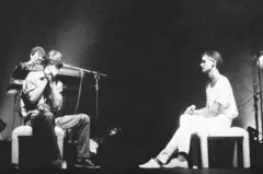 Cazuza sentado, em frente a gaitista