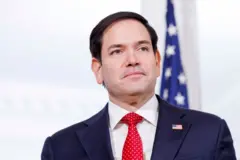 Marco Rubio de terno e gravata vermelha olhando para câmera