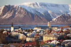 Una panorámica de una ciudad de Islandia, con un increíble atardecer y una montaña congelada en el fondo.