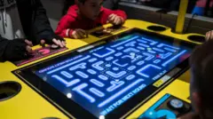 pantalla de juego de mesa grande con niños jugando pac-mac