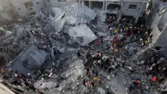 Abanya-Palestina bariko barondera abapfuye n'abakomeretse mw'ikambi y'impunzi ya  Al-Maghazi , Gaza, 5 Munyonyo 