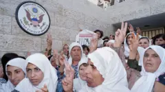 فلسطينيات يرفعن علامة النصر ويغنين أغاني وطنية عند القنصلية الأمريكية في القدس، بعد تسليم رسائل احتجاجية على السياسة الإسرائيلية تجاه السجناء الفلسطينيين في 8 أكتوبر/تشرين الأول 1992
