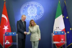 Erdoğan ve Meloni kürsünün önünde el sıkışıyor.