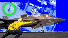 Un aviador de la Armada estadounidense le da la señal de despegue a un caza F-35.