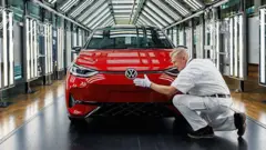 Um operário limpa um carro Volkswagen vermelho com uma flanela antes que ele saia da fábrica