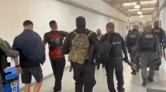 Policiais com preso algemado