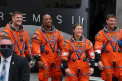 Os quatro astronautas, vestidos e prontos para embarcar no foguete que os levou ao espaço.