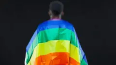 Umugabo wifubitse mu bitugu ibendera ry'abatinganyi