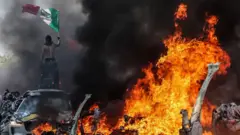 Pengunjuk rasa melambaikan bendera Meksiko saat menggelar aksi protes di Los Angeles, padaMinggu (08/06).