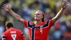 Erling Haaland, de Noruega, de braços abertos comemorando um gol.