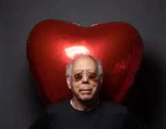 Macalé usando óculos escuros. Atrás dele há um balão inflável em formato de coração