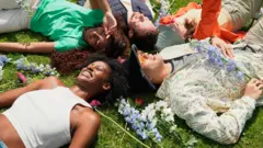 Grupo de pessoas alegres descansando na grama