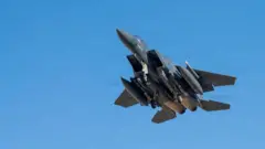 взлетающий боевой самолет F-15E, вид снизу