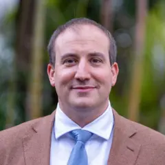 Retrato do professor Marko Milanovic, da Universidade de Reading (Reino Unido), com fundo desfocado. Ele usa terno e gravata e sorri com a boca fechada.