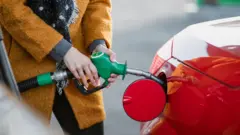 Arabaya benzin koyan bir kişi