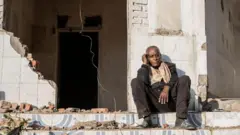 ኣብ ዝዓነወ ገዛ ኮፍ ዝበሉ ኣቦ