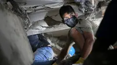 Voluntario entre los escombros de un edificio derrumbado en La Guaira
