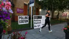 Женщина бежит мимо избирательного участка в Лондоне 4 июля 2024 года