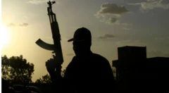 صورة تظهر ظل رجل مسلح يشهر سلاحه إلى أعلى