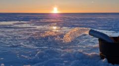 Bomba de agua de mar en acción con la puesta de sol sobre el Ártico al fondo