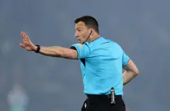 Garsoore Felix Zwayer oo dhexdhexaadinaya lugta labaad cayaartii PSG iyo Arsenal.