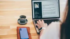 дівчина з відкритим резюме на комп'ютері