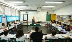 Alunos em sala de aula escutam professora