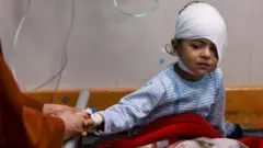 Menino ferido, com a cabeça enfaixada,onabet dashboardcamaonabet dashboardhospitalonabet dashboardKhan Younis, Gaza,onabet dashboardnovembroonabet dashboard2023