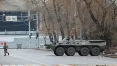 Қозоғистон. Шаҳар кўчасида бронетранспортер ва аскар