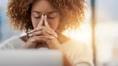 Une femme devant son ordinateur réfléchit
