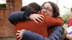 Rhiannon Davies (left) embraces Kayleigh Griffiths, following the release of the final report by Donna Ockenden
