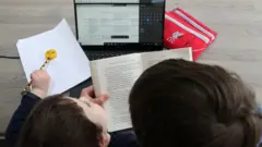 Criança estudando em casa, em foto de 2021