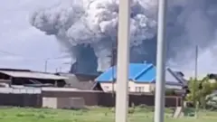 Fumaça sobe sobre a área após o que as autoridades locais chamaram de ataque de drone contra uma unidade militar na vila de Sredny, na Rússia.