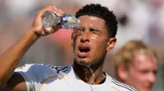 白いユニフォームを着た選手が、ペットボトルの水を頭から被っている