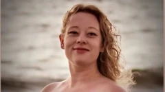 Женщина с длинными светлыми волосами в платье или кофте, оставляющими открытыми плечи