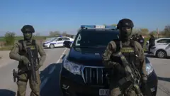 Vojna policija pod punom opremom sa puškama u rukama, na cesti stoji ispred automobila