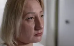 زنی با موهای بلوند به دوردست‌ها نگاه می‌کند.