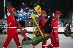 Unos trabajadores de Pdvsa cargan una maqueta de un balacín de petróleo.