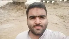 Tariq standing in front of a swollen river